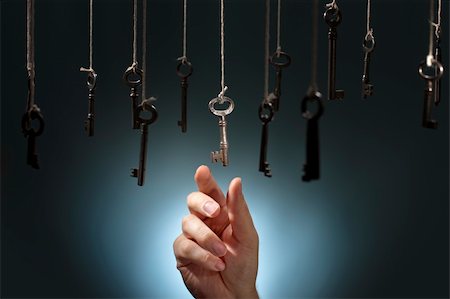 finger key - Hand choosing a hanging key amongst other ones. Stock Photo - Budget Royalty-Free & Subscription, Code: 400-06422988
