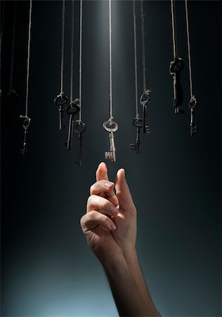 Hand choosing a hanging key amongst other ones. Foto de stock - Super Valor sin royalties y Suscripción, Código: 400-06422989