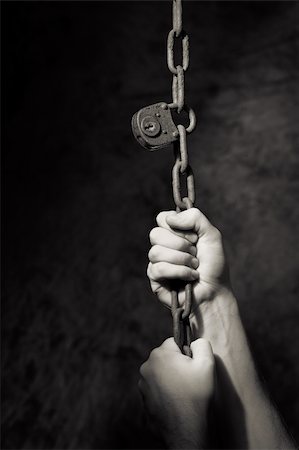 Monochrome image of hands pulling an old lock and chain. Stock Photo - Budget Royalty-Free & Subscription, Code: 400-06422992