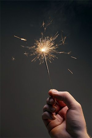 Man holding a burning sparkler firework in his hand. Foto de stock - Super Valor sin royalties y Suscripción, Código: 400-06423008