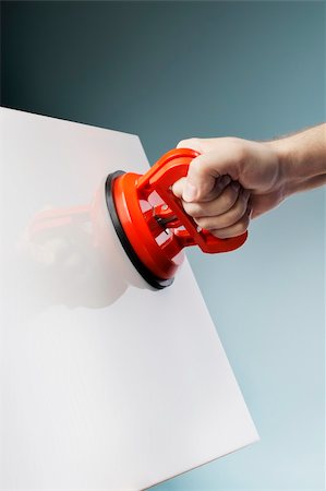 suzione - Man lifting a white ceramic tile using a vacuum suction cup tool aka dent puller. Fotografie stock - Microstock e Abbonamento, Codice: 400-06423011