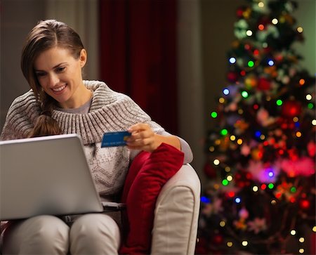 Happy woman with laptop and credit card in front of Christmas tree Stock Photo - Budget Royalty-Free & Subscription, Code: 400-06458804