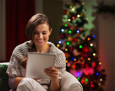 simsearch:400-06419734,k - Happy woman looking in tablet PC in front of Christmas tree Stock Photo - Budget Royalty-Free & Subscription, Code: 400-06458808
