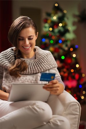 Happy woman with tablet PC and credit card in front of Christmas tree Stock Photo - Budget Royalty-Free & Subscription, Code: 400-06458817