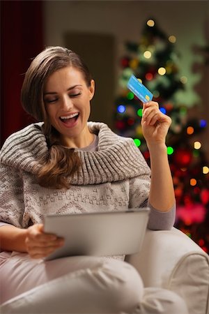 Happy woman in front of Christmas tree making online purchases Stock Photo - Budget Royalty-Free & Subscription, Code: 400-06458823