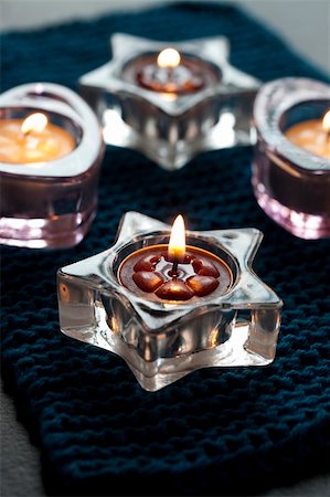 Close up of candles in shaped glass holders on a blue mat Stock Photo - Budget Royalty-Free & Subscription, Code: 400-06459163