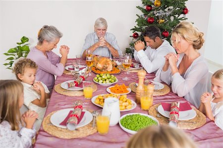 simsearch:400-06871557,k - Family saying grace together before christmas dinner Photographie de stock - Aubaine LD & Abonnement, Code: 400-06459305