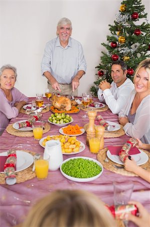 simsearch:400-06871557,k - Happy grandfather carving the christmas turkey at the dinner table Photographie de stock - Aubaine LD & Abonnement, Code: 400-06459302