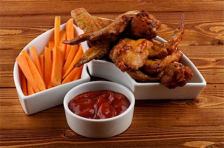 Chicken Wings, Carrot Sticks and Barbecue Dressing in White Bowls on Wood background Stock Photo - Budget Royalty-Free & Subscription, Code: 400-06460965
