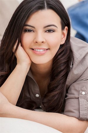 simsearch:400-07112758,k - Portrait of a beautiful young Latina Hispanic woman smiling laying down and relaxing at home on a sofa Fotografie stock - Microstock e Abbonamento, Codice: 400-06461314