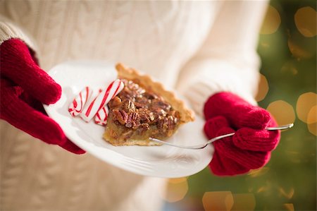 simsearch:400-06462603,k - Woman Wearing A Sweater and Seasonal Red Mittens Holding A Plate of Pecan Pie with Peppermint Sticks. Stock Photo - Budget Royalty-Free & Subscription, Code: 400-06462606
