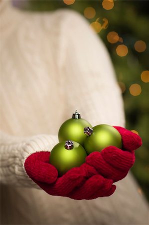 simsearch:400-06462603,k - Woman Wearing A Sweater and Seasonal Red Mittens Holding Three Green Christmas Ornaments. Stock Photo - Budget Royalty-Free & Subscription, Code: 400-06462610