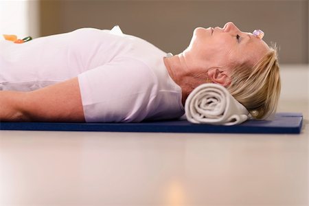 simsearch:400-06461903,k - Senior woman relaxing and lying on pad with amethyst, quartz and other crystals on body. Side view, copy space Foto de stock - Royalty-Free Super Valor e Assinatura, Número: 400-06463058