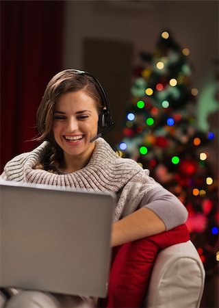 Happy young woman having video chat with family in front of Christmas tree Photographie de stock - Aubaine LD & Abonnement, Code: 400-06463585