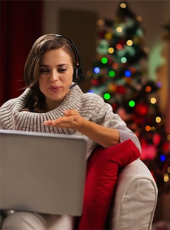 Happy young woman having video chat with lover in front of Christmas tree Stock Photo - Budget Royalty-Free & Subscription, Code: 400-06463586