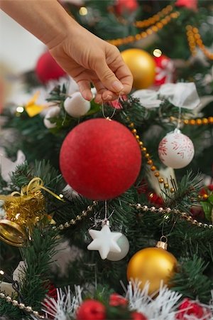 people decorate christmas tree - Closeup on woman hand hanging Christmas ball on Christmas tree Stock Photo - Budget Royalty-Free & Subscription, Code: 400-06463674