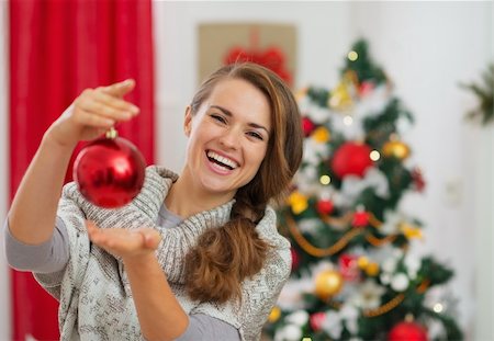 people decorate christmas tree - Happy young woman holding Christmas ball in front of Christmas tree Stock Photo - Budget Royalty-Free & Subscription, Code: 400-06463672