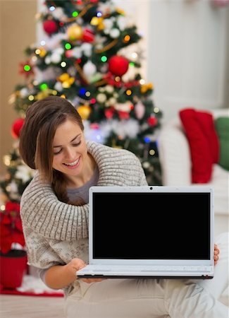 simsearch:400-06419734,k - Happy woman looking laptop blank screen near Christmas tree Stock Photo - Budget Royalty-Free & Subscription, Code: 400-06463702