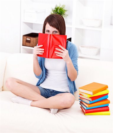 simsearch:614-06442418,k - Girl hiding behind book on the sofa Foto de stock - Super Valor sin royalties y Suscripción, Código: 400-06476896