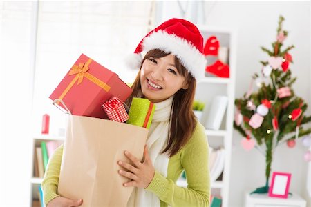 simsearch:400-06477682,k - Happy Asian female holding many Christmas gift, inside home. Stock Photo - Budget Royalty-Free & Subscription, Code: 400-06477685