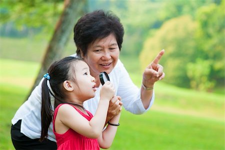 Asian grandmother and granddaughter exploring nature by magnifier Stock Photo - Budget Royalty-Free & Subscription, Code: 400-06479257