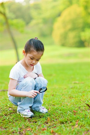 Little Asian girl exploring nature by magnifier Stock Photo - Budget Royalty-Free & Subscription, Code: 400-06479253