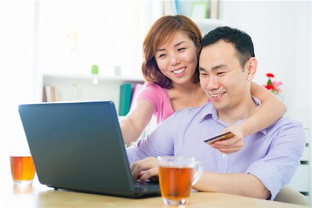 Happy Asian couple shopping online with credit card and computer at home Stock Photo - Budget Royalty-Free & Subscription, Code: 400-06479283