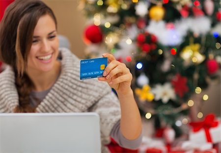 Closeup on credit card in hand of happy woman with laptop near Christmas tree Stock Photo - Budget Royalty-Free & Subscription, Code: 400-06484198