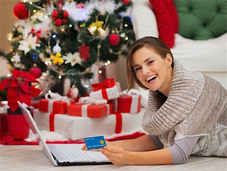 Happy woman with laptop near Christmas tree making online purchases Stock Photo - Budget Royalty-Free & Subscription, Code: 400-06484199
