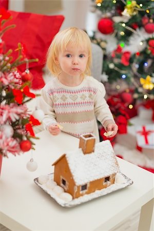 Portrait of baby eating cookies near Christmas Gingerbread house Fotografie stock - Microstock e Abbonamento, Codice: 400-06484211