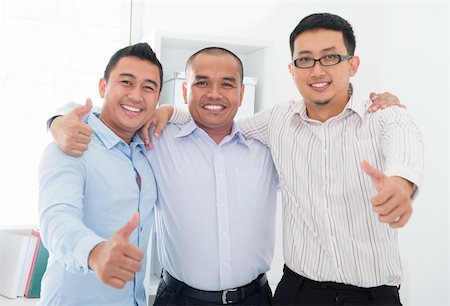 Thumbs up Southeast Asian businessmen standing in office Foto de stock - Super Valor sin royalties y Suscripción, Código: 400-06484585