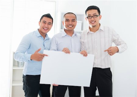 Southeast Asian business team holding a blank banner in office Stock Photo - Budget Royalty-Free & Subscription, Code: 400-06484586