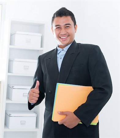 Thumb up Southeast Asian executive standing in office Stock Photo - Budget Royalty-Free & Subscription, Code: 400-06484583