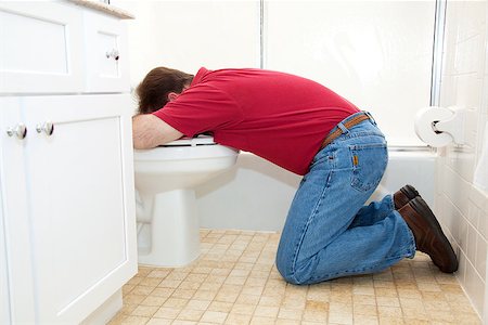 Man on his knees in the bathroom, vomiting into the toilet. Stock Photo - Budget Royalty-Free & Subscription, Code: 400-06485560