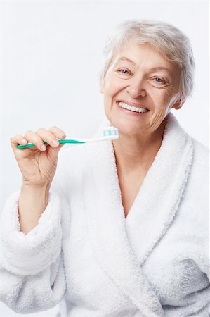 simsearch:400-06482471,k - Elderly woman with a toothbrush on white background Stock Photo - Budget Royalty-Free & Subscription, Code: 400-06482474