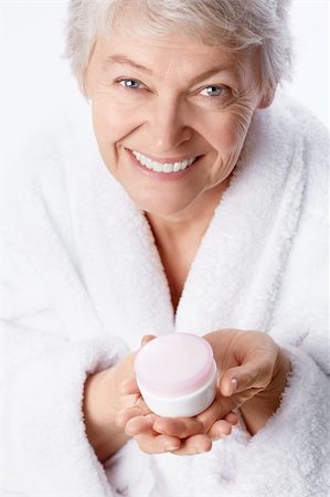 simsearch:400-06482471,k - Elderly woman with cream on a white background Stock Photo - Budget Royalty-Free & Subscription, Code: 400-06482475