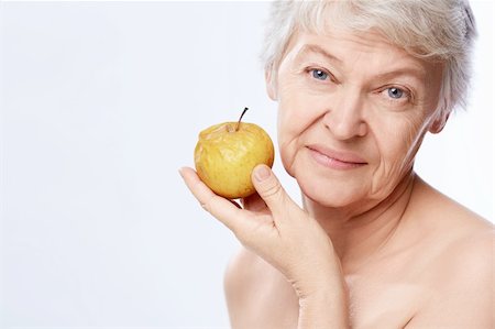 simsearch:400-06482471,k - Elderly woman with an apple on a white background Stock Photo - Budget Royalty-Free & Subscription, Code: 400-06482479