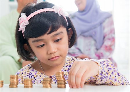 Muslim banking concept. Southeast Asian saving money at home, asian family living lifestyle. Stock Photo - Budget Royalty-Free & Subscription, Code: 400-06483268