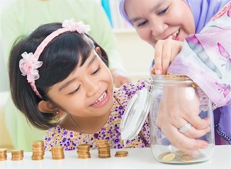 Muslim mother and daughter saving money at home. Southeast Asian family living lifestyle. Stock Photo - Budget Royalty-Free & Subscription, Code: 400-06483270