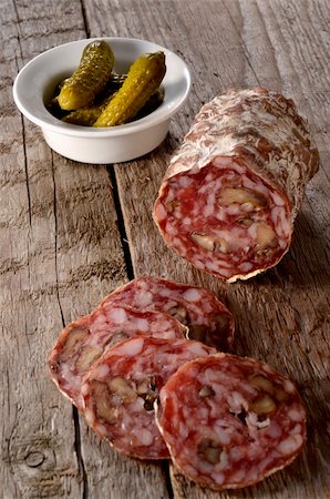 Slice salami with pickled cucumbers on a rustic wooden surface Stock Photo - Budget Royalty-Free & Subscription, Code: 400-06517496