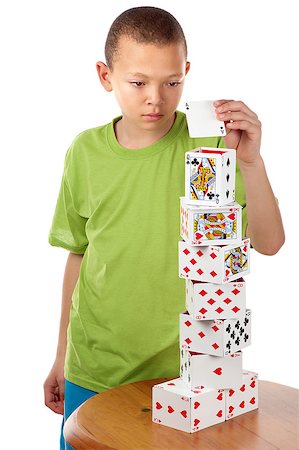 playing cards towers - A hard concentrating boy completes his playing card tower project by placing the last card on top of it. Stock Photo - Budget Royalty-Free & Subscription, Code: 400-06524909