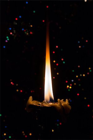 simsearch:614-00387940,k - Burning candle on a dark background with small lights. Photographie de stock - Aubaine LD & Abonnement, Code: 400-06525003