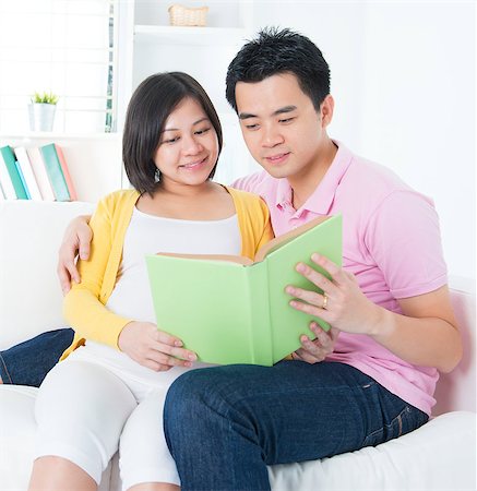 Asian couple reading book together, sitting on sofa Stock Photo - Budget Royalty-Free & Subscription, Code: 400-06525114