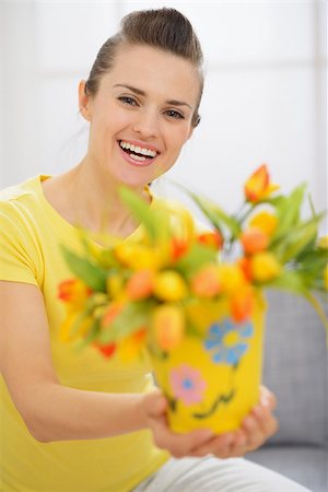 Happy young woman showing bouquet of tulips in bucket Stock Photo - Budget Royalty-Free & Subscription, Code: 400-06525182