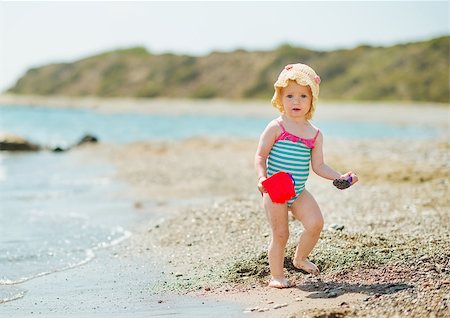 Baby playing with pail on sea shore Photographie de stock - Aubaine LD & Abonnement, Code: 400-06525219