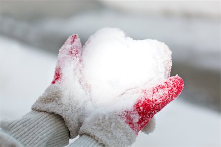 Hands in red mitten hold snow like a heart background Stock Photo - Budget Royalty-Free & Subscription, Code: 400-06525365
