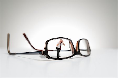 Conceptual photograph of life size glasses and a male model looking through one side of the eyeglasses. Stock Photo - Budget Royalty-Free & Subscription, Code: 400-06525387