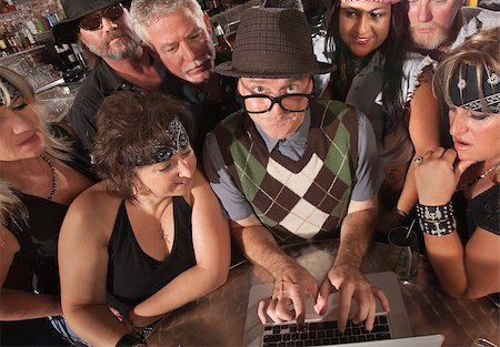 simsearch:400-06558607,k - Mature nerd troubleshooting a computer with biker gang Stock Photo - Budget Royalty-Free & Subscription, Code: 400-06525844