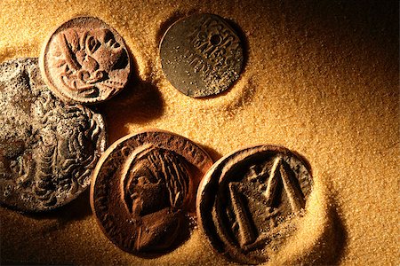Few ancient coins on sand background under beam of light Foto de stock - Super Valor sin royalties y Suscripción, Código: 400-06525857