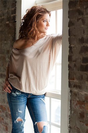 Attractive young woman standing by the window Stock Photo - Budget Royalty-Free & Subscription, Code: 400-06527656